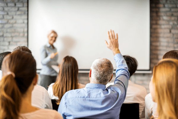 Homme qui pose une question à une conférence